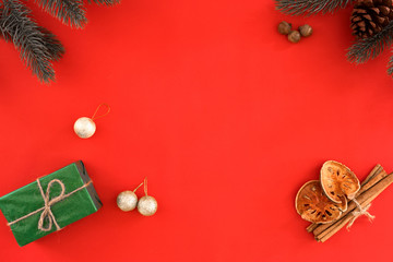 Christmas and New Year background - Christmas gift, fir leaves and Xmas  decoration on red background. Holiday concept. Creative flat lay, top view design