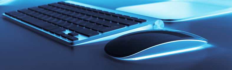 Business workplace with computer wireless keyboard and mouse on old blue table background. Office...