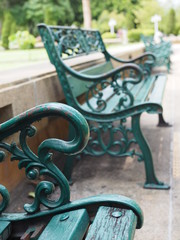 Green wooden steel benches in a park, perspective stacking