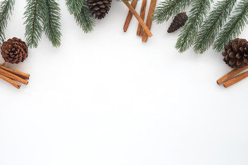 Christmas and New year background with fir leaves, pine cones and cinnamol on white background. Creative flat lay, top view design with copy space