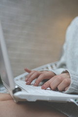 Woman hands typing on laptop. Close up portrait of a woman hands working with a laptop at home.