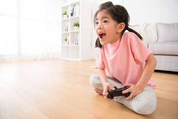 little girl holding joystick happy play video game