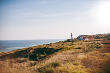 Fototapeta na wymiar Lighthouse over the sea near the house