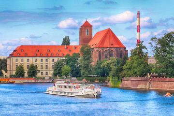 Naklejka premium WROCLAW, POLAND - AUGUST 14, 2017: Wroclaw Old Town. Cathedral Island (Ostrow Tumski) is the oldest part of the city. Odra River, boats and historic buildings on a summer day.