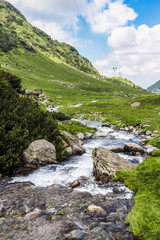 Fototapeta na wymiar View of the Fagaras mountains and water stream in Carpathians, Romania, spectacular wilderness scenery