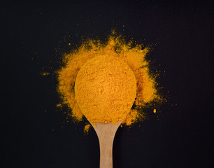 Turmeric powder on black background.