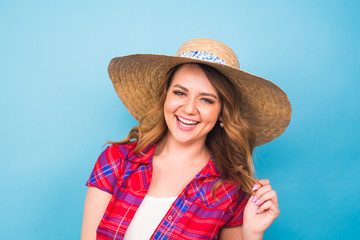 Holidays, summer, fashion and people concept - Girl in fashionable clothes straw hat. Portrait of charming woman on blue background with empty copy space