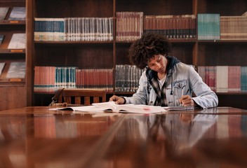University student doing assignment in library