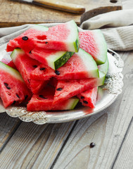 Fresh sliced watermelon in a metal bowl wooden background