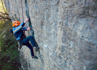 Fototapeta premium Kid rock climber climbs the cliff.