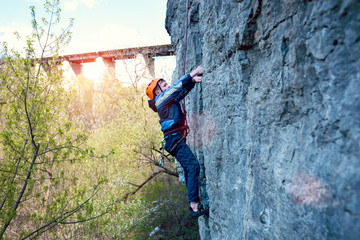 Obraz premium Kid rock climber climbs the cliff.