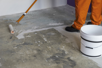 Interior of apartment under renovation. Man holding a roller and