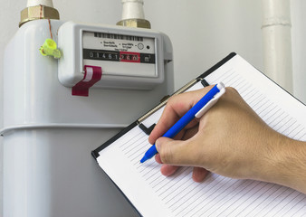 Person reading the gas meter in the private house, counter for distribution domestic gas. Cropped...