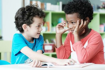 Two boys studying together with happy emotion in their classroom, kid education concept