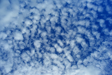 White fluffy clouds on blue sky for background.