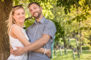 Fototapeta premium the young girl embracing the young man against the background of trees