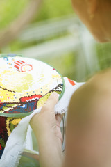 Fototapeta premium Hands of a woman, cross-stitch, close-up