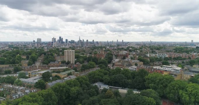 Aerial pull out view of the skyline of central London from a park