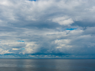 Naklejka na ściany i meble Gloomy clouds hovered over the surface of the sea