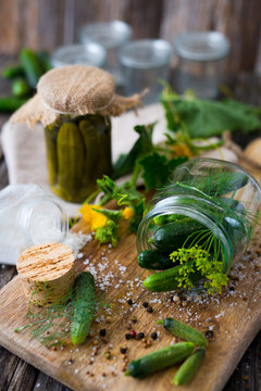 Jars of pickled marinated cucumbers on rustic table