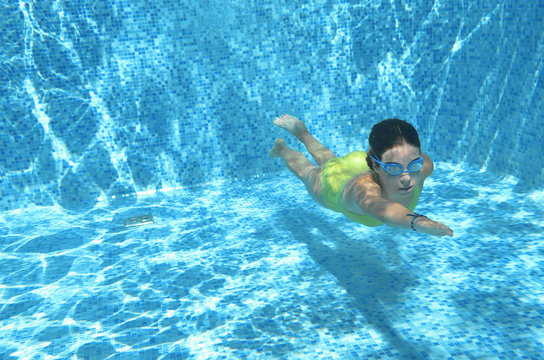 Young girl swimmer swimming under water in pool and has fun, teenager diving underwater, family vacation, sport and fitness concept
