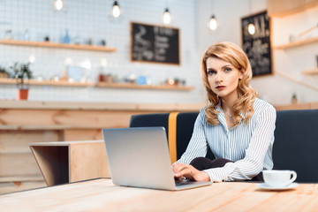 businesswoman using laptop in cafe