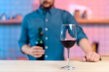 man pouring wine in glass