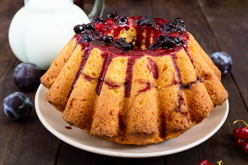 Fototapeta na wymiar Large freshly baked cake with summer berries on a dark wooden table.
