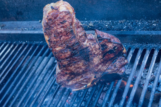 bistecca fiorentina motlo grande sulla griglia a fuoco motlo fortecon barbecue ,rosmarino e sale 