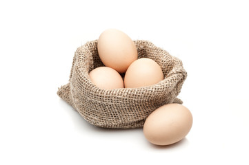 chicken eggs in burlap sack isolated on white background