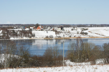 Countryside lake in winter from small hill.