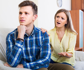 family couple with serious faces quarrelling at home