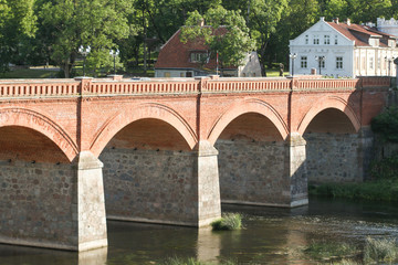 Classic, historic brick bridge over small river.