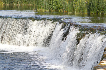 Fototapeta na wymiar Small waterfall in countryside.