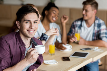 man drinking coffee with friends