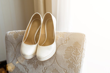 Wedding shoes on the back of the armchair near the window