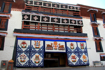 the part of the Potala Palace, with the people republic of China flag inside as well as many windows, curtain, Brick wall, Potala Palace square, Tibet Admiralty, golden chimes and Colored prayer   © shenmanjun