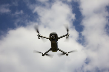 The drone flying over the blue sky background to take a photo / The flying drone on the sky