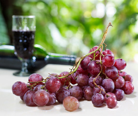 Bunch of Grape and wine in the glass on tile plate