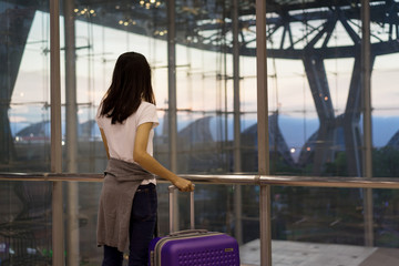 Fototapeta premium Young girl traveler using mobile smartphone with carrying hold suitcase luggage and passenger for tour travel booking ticket flight in airport international vacation time in holiday relaxation.