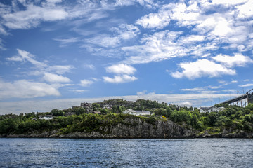 Fototapeta premium Norway coast with charming cottages in the background, summer, sunny sky with clouds.