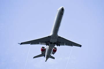 View of an airplane flying over the sky, view from below.