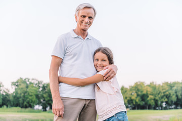 smiling grandfather and granddaughter