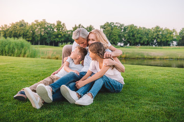 family resting on meadow