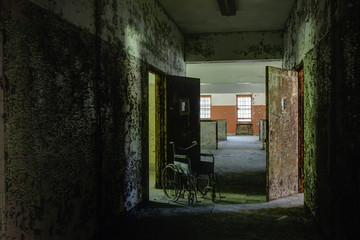 Fototapeta na wymiar Hallway with Vintage Wheelchair & Open Doors - Abandoned Hospital