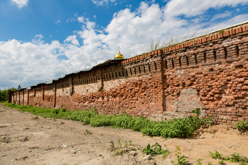 The old destroyed brick wall and the golden dome of the church
