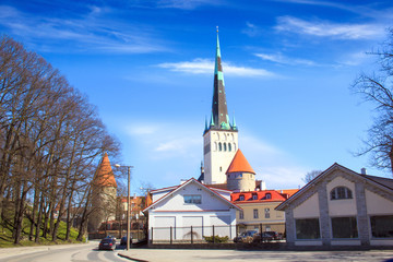 Fototapeta na wymiar Beautiful view of the tower Oleviste Churchand the Fortress wall in Tallinn, Estonia, on a sunny day