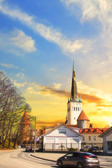 Fototapeta premium Beautiful view of the tower Oleviste Churchand the Fortress wall in Tallinn, Estonia, on a sunny day