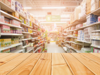 Wooden table in front of abstract blurred shopping mall background. For present your products.