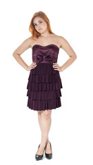 Girl is standing and legs are crossed. Pose for the picture. Redheaded girl wearing dark purple strapless dress.